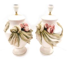 A pair of painted resin urn table lamps, each decorated with swags and roses, etc., 48m high.