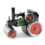 A scale live steam model of a traction engine, painted in black, green and red, possibly Mamod but u