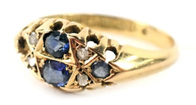 An 18ct gold gypsy ring, set with four oval sapphires (1 missing) and four tiny diamonds, each in cl