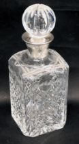 A cut glass square section decanter and stopper, with silver collar, 27cm high.