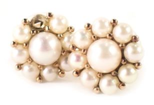 A pair of pearl cluster earrings, each cluster formed of cultured pearl in claw setting, central pea