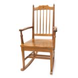 An Alan 'Acornman' Grainger oak rocking chair, with spindle turned back, solid seat and shaped arms,