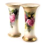A pair of Royal Worcester blush ivory porcelain wasted cylindrical vases, painted with roses, printe