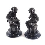 A pair of bronzed spelter figures, each modelled in the form of a putto with dogs, on ebonised base,