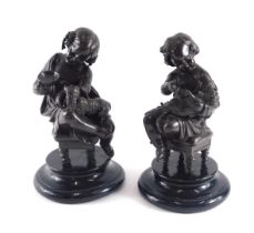 A pair of bronzed spelter figures, each modelled in the form of a putto with dogs, on ebonised base,