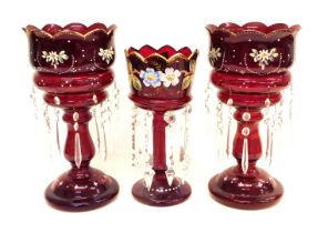 A pair of Victorian ruby tinted glass table lustres, each decorated with raised enamels with flowers