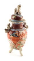 A Japanese earthenware vase and cover, the cover cast with a kylin or dog of fo, the base decorated