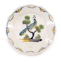 A 19thC French Faience La Rochelle style plate, decorated with a peacock on a branch, 23cm diameter.