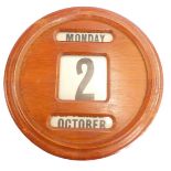 An oak cased wall calendar, with day, date and month reels, 41cm diameter.