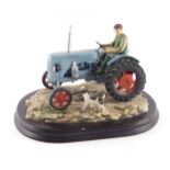A Leonardo Collection model of a farmer with blue tractor and dog, 22cm long.