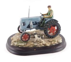 A Leonardo Collection model of a farmer with blue tractor and dog, 22cm long.