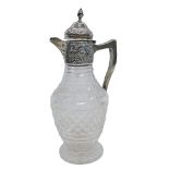 A late Victorian silver and cut glass claret jug, with acorn finial top, on hinged lid with floral e