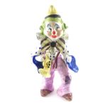 A large Italian pottery figure of a clown, with trumpet, etc., 55cm wide. (AF)