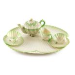 A Belleek porcelain cabaret tea set, comprising shell shaped tray, teapot, cup, two saucers, milk ju