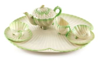 A Belleek porcelain cabaret tea set, comprising shell shaped tray, teapot, cup, two saucers, milk ju