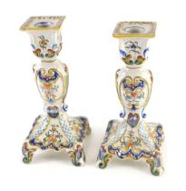 A pair of Fourmaintraux Freres Desvres candlesticks, each decorated with foliate scrolls, flowers, e