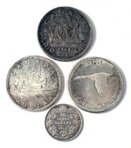 Four Canadian coins, a 1965 dollar, a 1967 commemorative dollar, 1949 dollar, and a 1914 twenty five