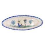 A large 19thC Quimper oval platter, decorated with a lady sewing and gentleman playing a musical ins