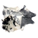 A quantity of cow hide rugs, various sizes and patterns.