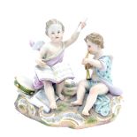 A late 19thC Meissen porcelain figure group, modelled in the form of a putto playing music, etc., on