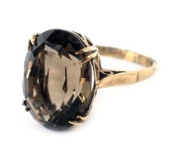 A 9ct gold smoky quartz dress ring, the oval smoky quartz in four double claw setting, in a raised b
