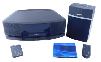 A Bose Wave Sound Touch music system, with instructions, and a Bose Bluetooth speaker.