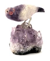 A quartz and amethyst carved bird, the bird perched on a rock with white metal mounts, 7cm high.