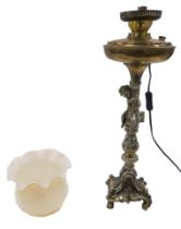 A Continental gilt metal table lamp, modelled in the form of an oil lamp, cast with a figure to the
