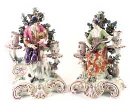 A pair of French Derby style porcelain candelabra, each modelled in the form of a male and female mu