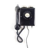 A black plastic wall mounted telephone, with two chrome plated bells.