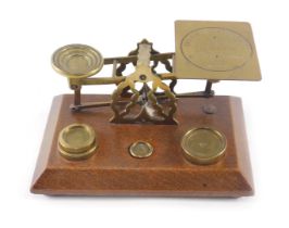 A set of early 20thC brass and oak letter scales, stamped Inland Letter Post, with some weights.