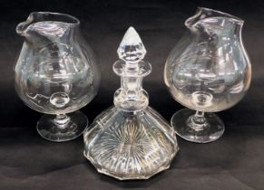 A pair of plain glass wine jugs, each on a wasted stem and domed foot, 24cm high, and a small ship s