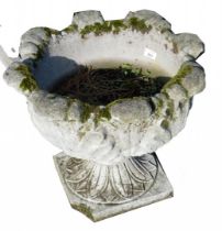A reconstituted stone planter on square foot, 40cm high, 45cm diameter. (AF)