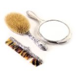 Three associated silver mounted dressing table items, to include hand mirror, brush and comb. (AF)