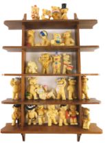 A large collection of ceramic bears, each wearing costume, etc., and a shelf.