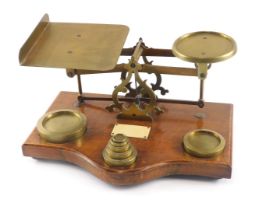 A set of brass and oak postal scales, with ivorine plaque and some weights.