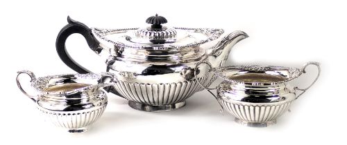 A George V silver three piece tea service, with shell capped beaded border, with fluted bodies, comp