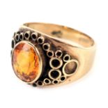 A 9ct gold Arts and Crafts style dress ring, with central oval cut citrine, in rub over setting, wit