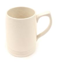 A Wedgwood cream glazed tankard or mug, designed by Keith Murray, 12cm high.