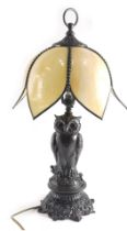 A bronzed metal owl table lamp, with marbled stain glass shade, and owl shaped support, 57cm high.