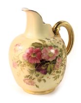 A Royal Worcester porcelain blush ivory ground ewer, decorated with pink and purple flowers and leav