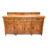 A late Victorian figured oak and oak sideboard, with a later raised back and a moulded edge, above t