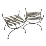 A pair of wrought iron stands, each with a slatted top and X shaped end supports, 50cm wide.