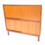 A 1960s/70s Carson teak two section cabinet, each with sliding doors and aluminium handles, on block