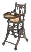 A late 19thC beech child's metamorphic high chair, with a pierced laminate seat, shaped legs and spo