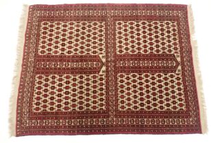 A Hatchli Turkoman rug, with an all over design of medallions, in red on a cream ground, with one wi