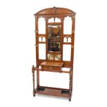 A late 19th/early 20thC oak hallstand, the top with a raised pediment above a bevelled mirror plate,