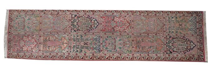 An Eastern runner, with a design of flowers within arches and compartments, in various colours with