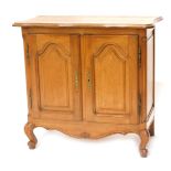 A French oak side cabinet, serpentine shaped top with a moulded edge, above two doors each with arch