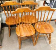 A set of four stained pine stick back kitchen chairs.